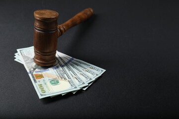 Law gavel with dollars on grey table, space for text