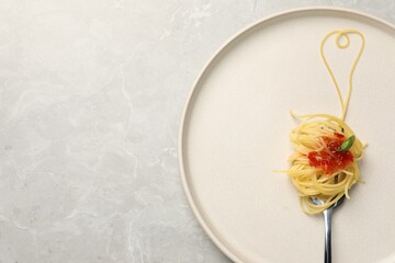 Heart made with spaghetti and fork on grey table, top view. Space for text