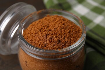 Ground red pepper in jar on table, closeup
