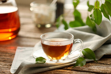 Tasty tea in cup on wooden table, closeup