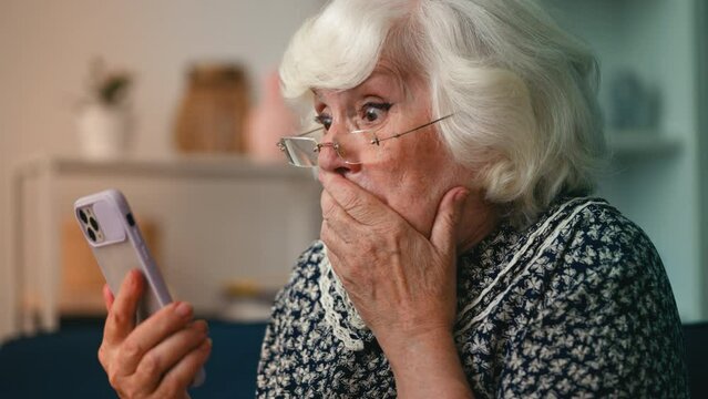 Humorous elderly woman astonished by shocking news she saw on her cellphone