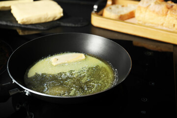Melting butter in frying pan on cooktop