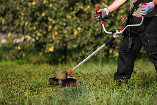Man mowing grass with a brushcutter