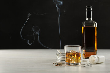 Alcohol and drug addiction. Whiskey in glass, bottle, cigarettes and pills on white table, space...