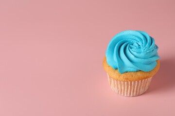 Delicious cupcake with bright cream on pink background, space for text