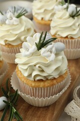 Tasty Easter cupcakes with vanilla cream on table, closeup