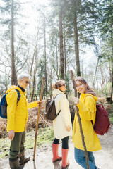Group of friends walking with backpacks in forest. Trekking travel in adventure lifestyle, nature hiking in vacation holiday with journey. Tourism, hiking, and friendship concept. Outdoor activities