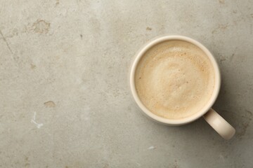Cup of coffee on grey table, top view. Space for text