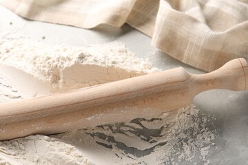 Pile of flour and rolling pin on grey marble table, closeup