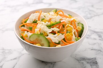 Tasty salad with Chinese cabbage, carrot, corn and cucumber in bowl on white marble table