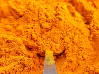 Turmeric powder on spoon close up