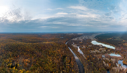 Aerial autumn Siverskyi Donets river valley panorama with colorful forest on riverbanks and blue sky with clouds in Ukraine