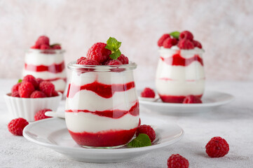 Vanilla white chocolate mousse, trifle, panna cotta or parfait with raspberry sauce in a glass jar....