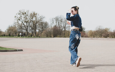 A young girl walks in the park near the old fortress