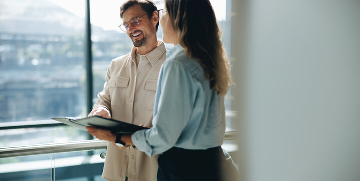Happy business professionals reading a document together in an office