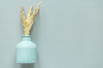 flatley plaster vase with dried flowers on a plain gray background. free space for text