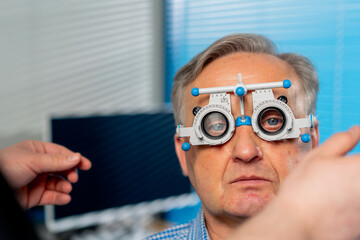 close up In an ophthalmology clinic obese doctor selects suitable lenses for a patient