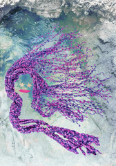 Abstract design woman mermaid figure art form with flowing purple pink hair emerges floating above blue bubble pool of water. Fabric sculpture has gold star eyes. Pond has rocky edges.