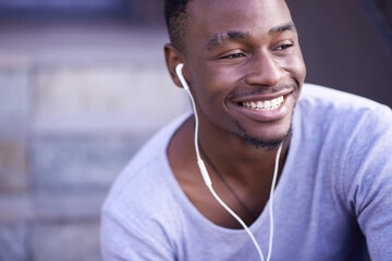 Black man, smile and earphones for music in city or streaming entertainment, subscription or...