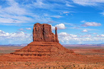 Arizona's Monument Valley East Mitten during a bright and partly cloudy day shows its beauty as it...