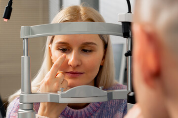 close up in an ophthalmology clinic young girl communicates with a doctor through a diagnostic...