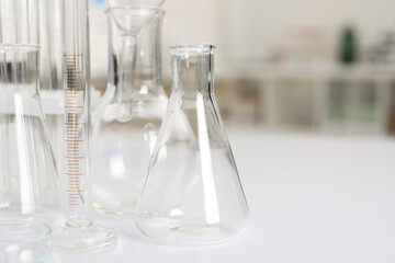 Laboratory analysis. Different glassware on white table indoors, closeup. Space for text