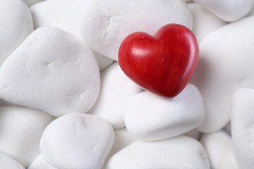 Obraz premium Decorative heart on white pebble stones, top view