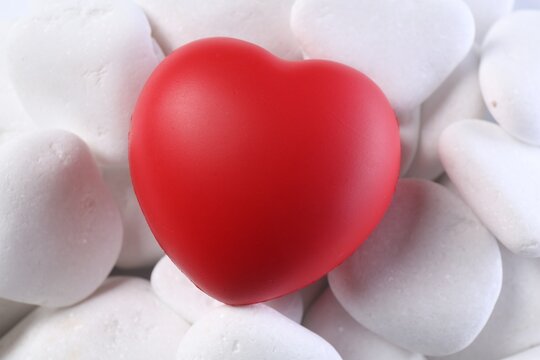 Decorative heart on white pebble stones, closeup