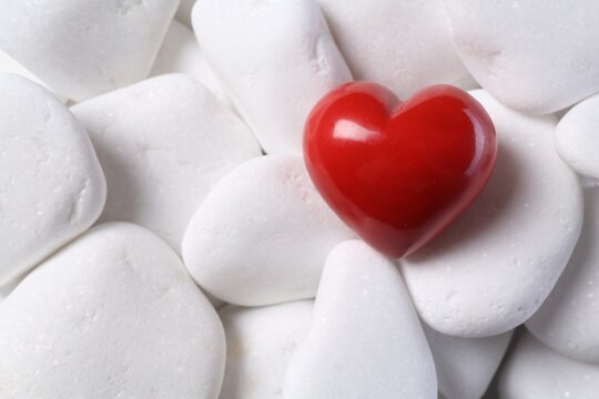 Decorative heart on white pebble stones, top view
