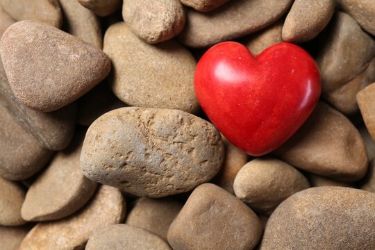 Red decorative heart on stones, top view