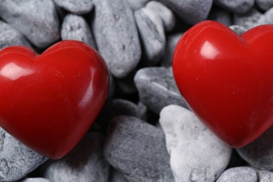 Red decorative hearts on grey stones, closeup