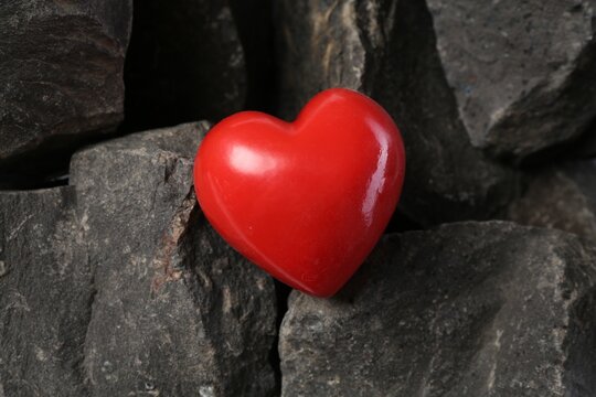 One red decorative heart on stones, above view