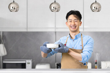 キッチンに立つ笑顔の男性・料理イメージ