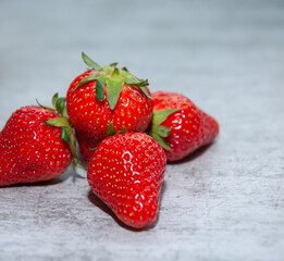 Closeup of fresh domestic strawberries on a grey background. Isolated. Food concept.