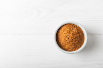 Cinnamon powder on a textured wooden background. Spicy spice for baking, desserts and drinks. Fragrant ground cinnamon. Cinnamon stick. Place for text. Copy space.