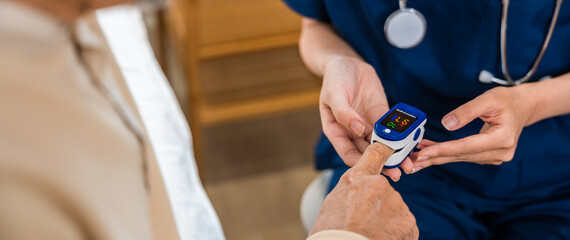Young woman putting digital oximeter of finger middle aged adult patient for measurement, nurse...