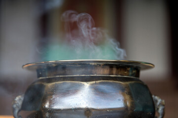 View of the incense burner with the smoke in the temple