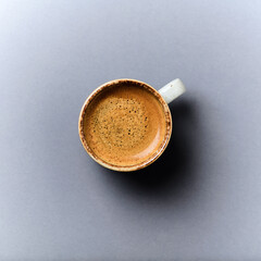 Cup of coffee on gray background. Top view.
