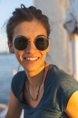 Portrait of a girl in sunglasses sitting on a yacht.
