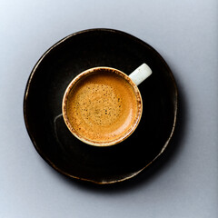 Cup of coffee on gray background. Top view.