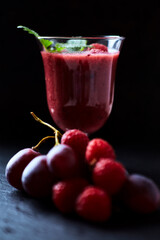Fresh smoothie in a glass. Dark background. Close up.