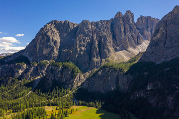 Stunning views of the idyllic Dolomites landscape with fresh green meadows and majestic mountain peaks.