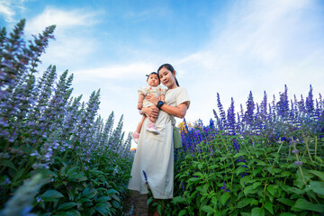 Mother and child in the flower field,mother and little daughter in a flowering lavender field enjoying her scent 