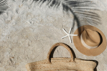 Summer vibes. Straw hat and beach bag on a beautiful white sand. Copy space for text. - obrazy, fototapety, plakaty