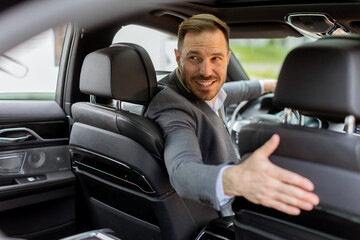 Fototapeta na wymiar Welcoming smile from a joyful driver in a luxury sedan on a sunny day