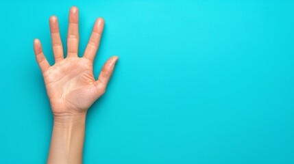   Person's hand elevated against a blue backdrop, one finger pointing upwards