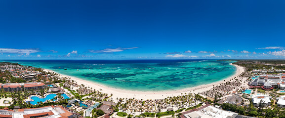 Aerial panorama of the large tropical beach with white sand and turquoise water of the Caribbean...