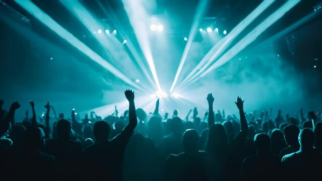 crowd in front of a bright stage with blue rays of light, Night club under blue rays beam and young people holding light, enjoying at concert concept
