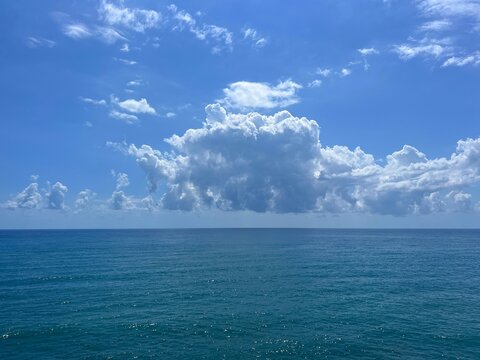 Sea shiny blue water and beautiful clouds in the sky