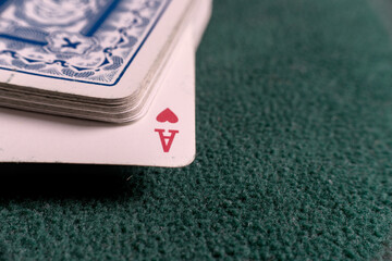 deck of cards with the ace of hearts in view on a green cloth